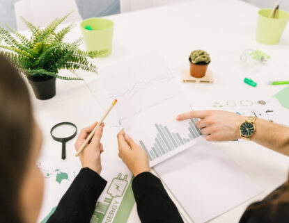 Two professionals reviewing bar and line charts during a growth strategy planning session.
